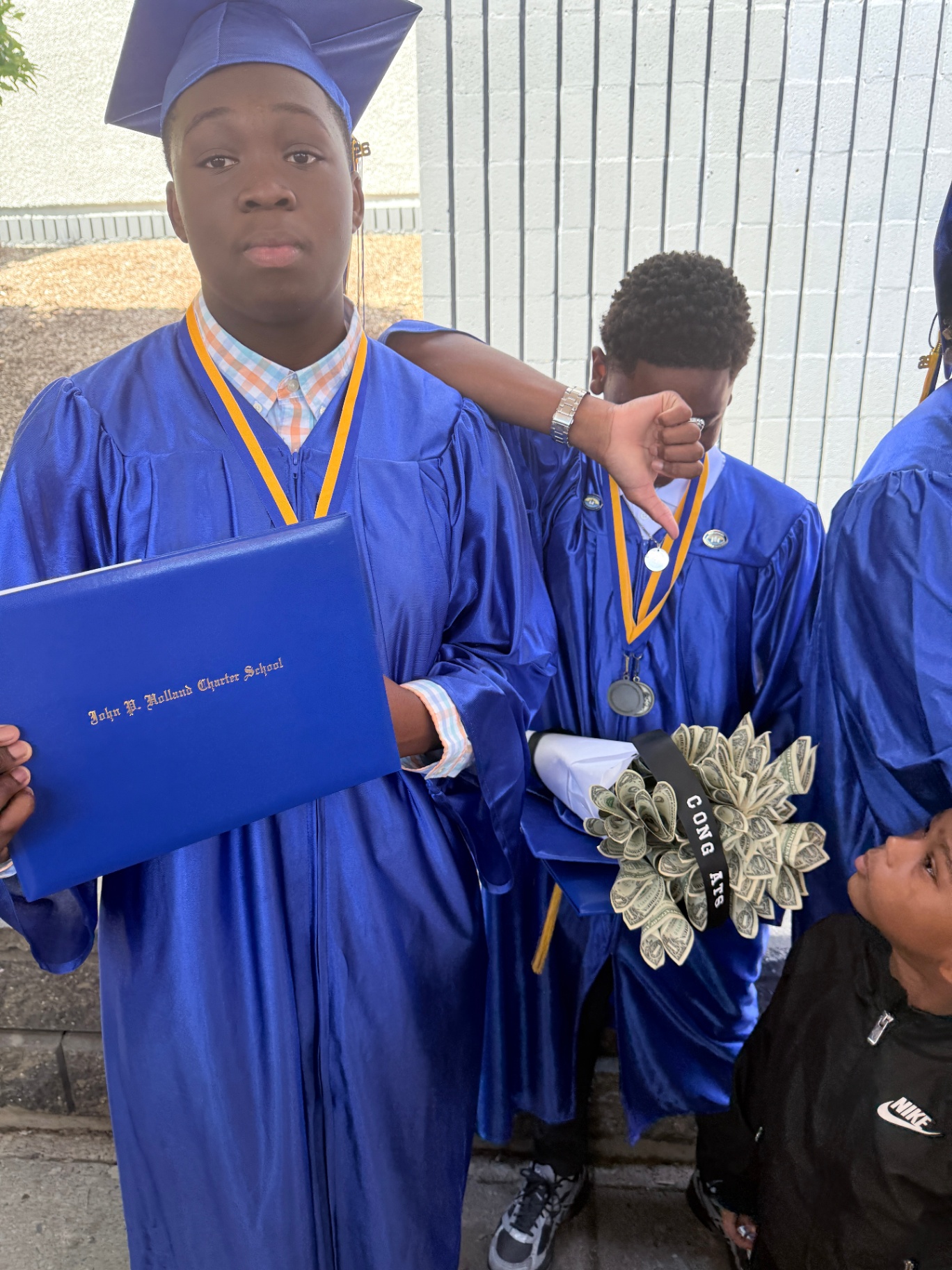 Zadon in cap and gown holding his John P. Holland diploma
